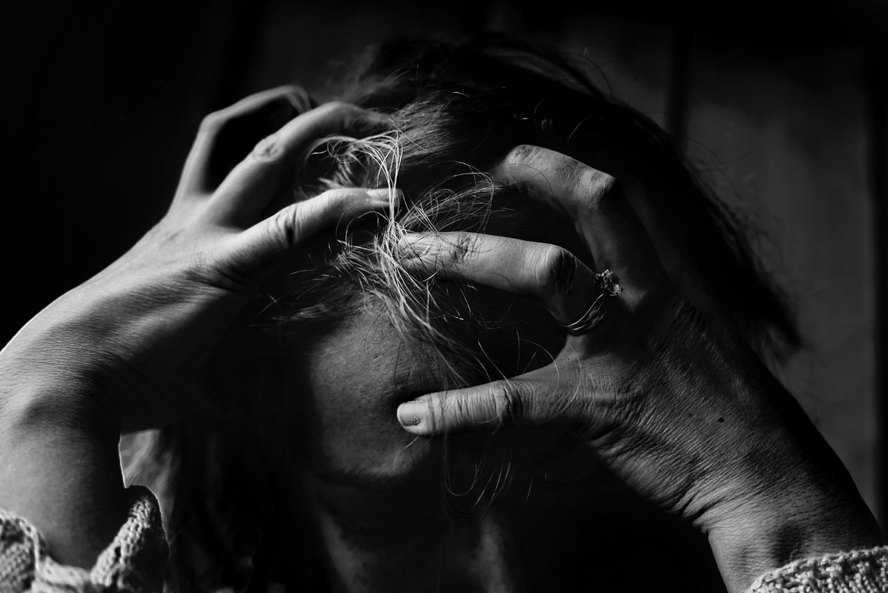 A Woman Holding Her Head Frustratedly
