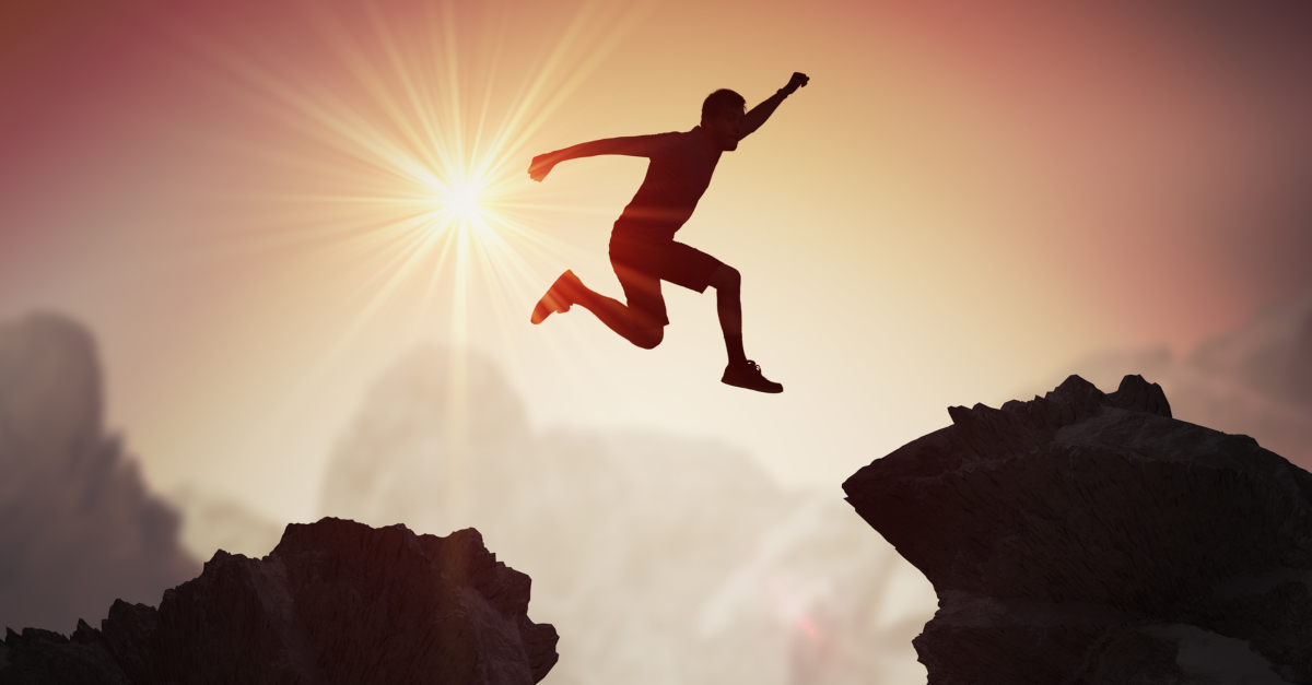 A fearless man jumping from one mountain to another