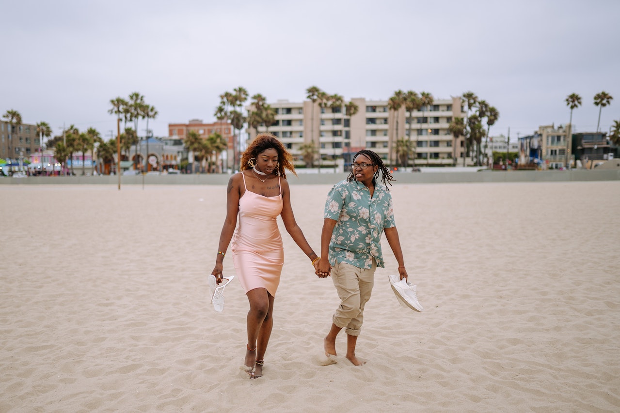 Couple Walking on the Beach while Holding Hands
