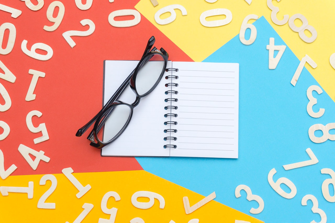 Eyeglasses With Black Frames surrounded by numbers in colorful surface