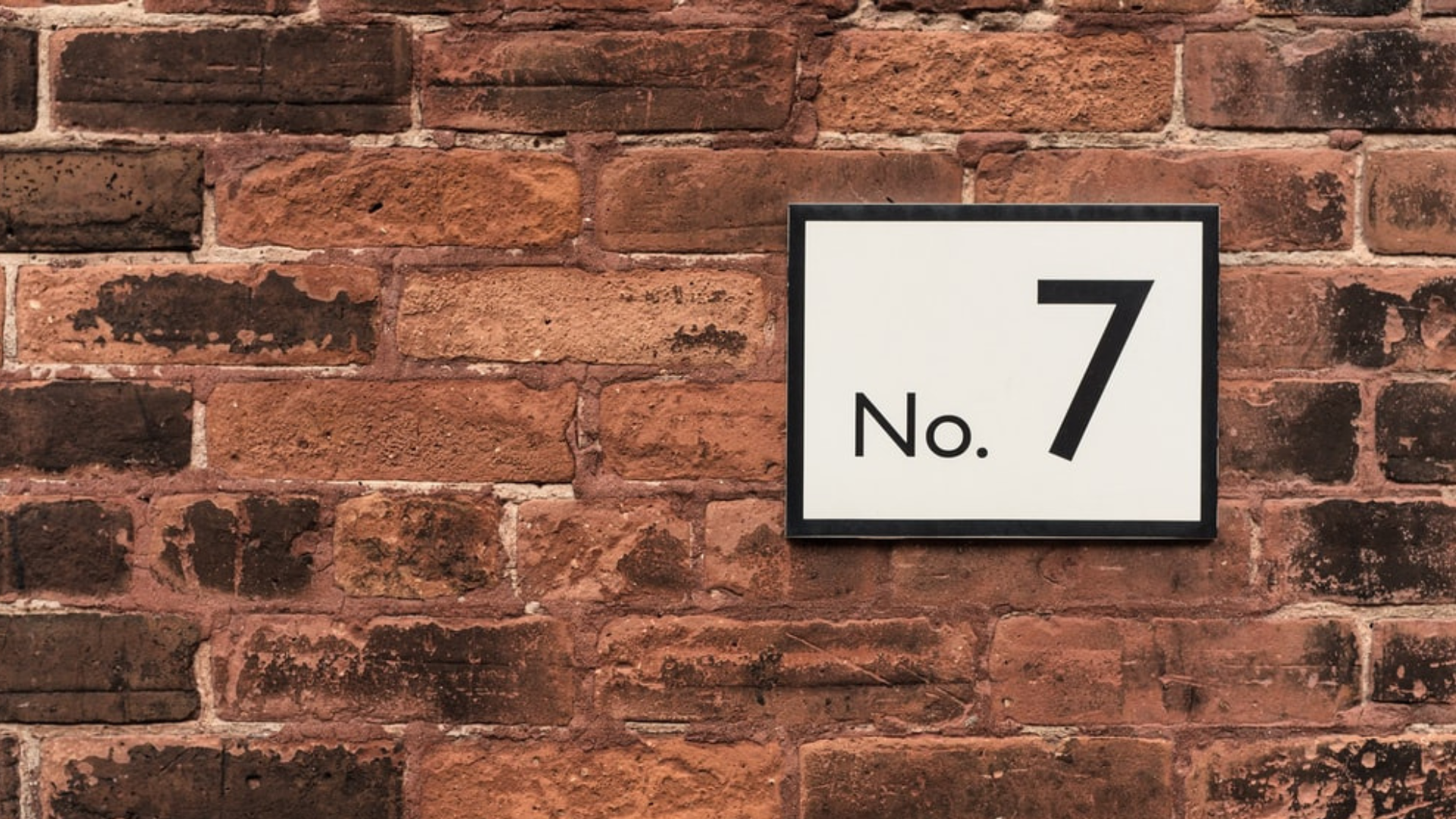 A brick wall with a number 7 house number