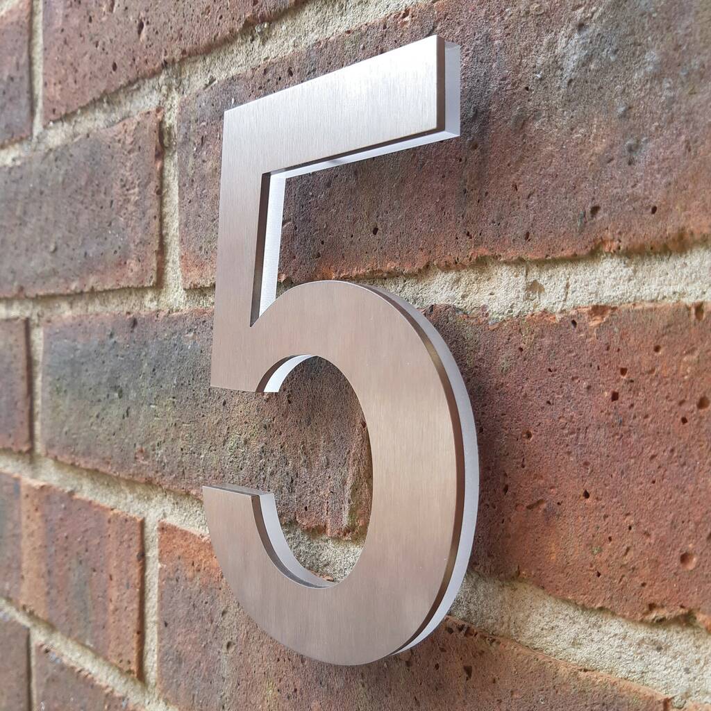 A brick wall with number 5 in silver color