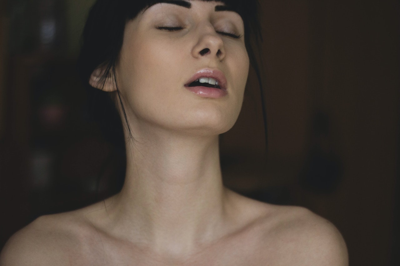 A woman with eyes closed and mouth parted