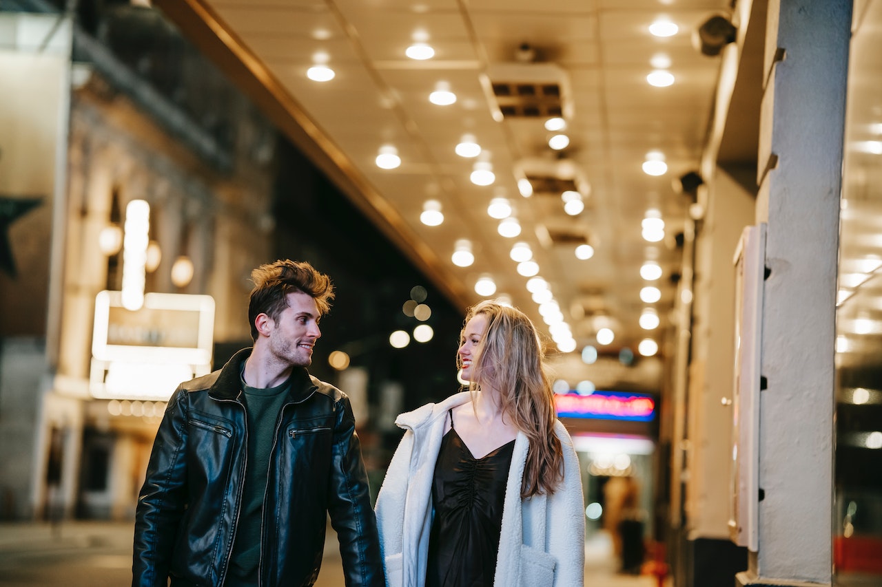 Couple looking at each other while walking holding hands
