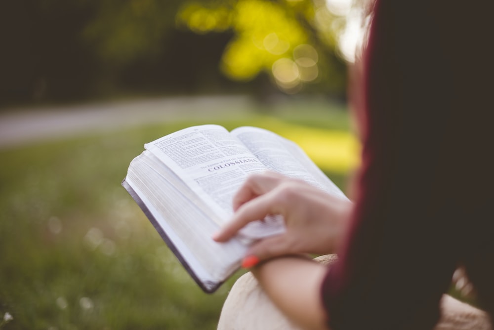 Woman's hand holding bible in lap