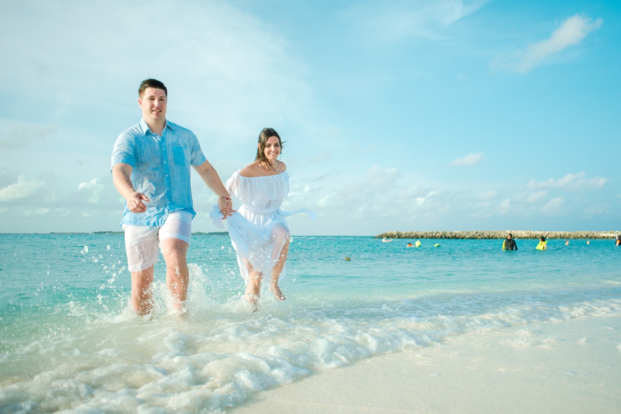 Man and Woman Running on Seashore