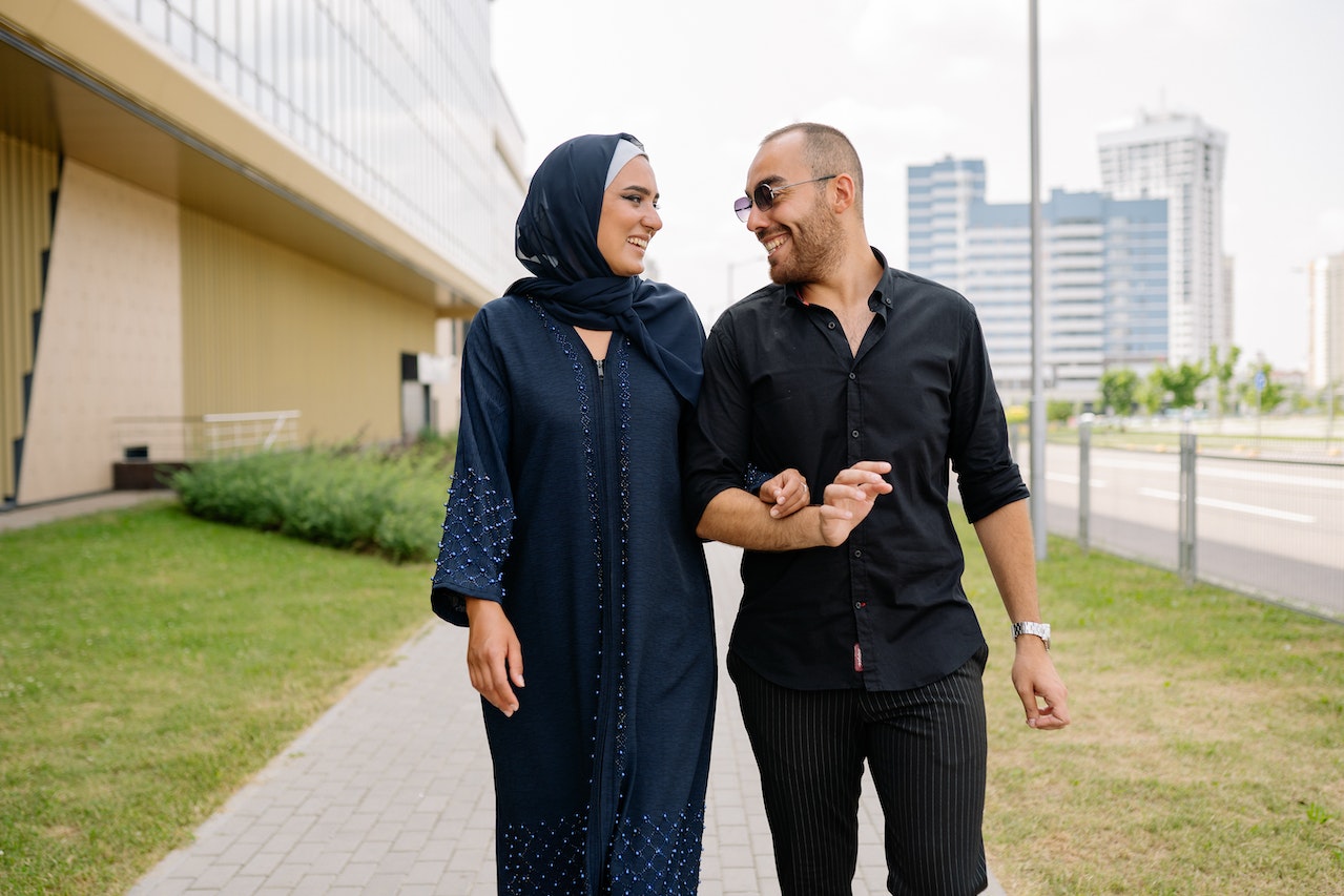 Couple Walking in Front of Building Looking at Each Other