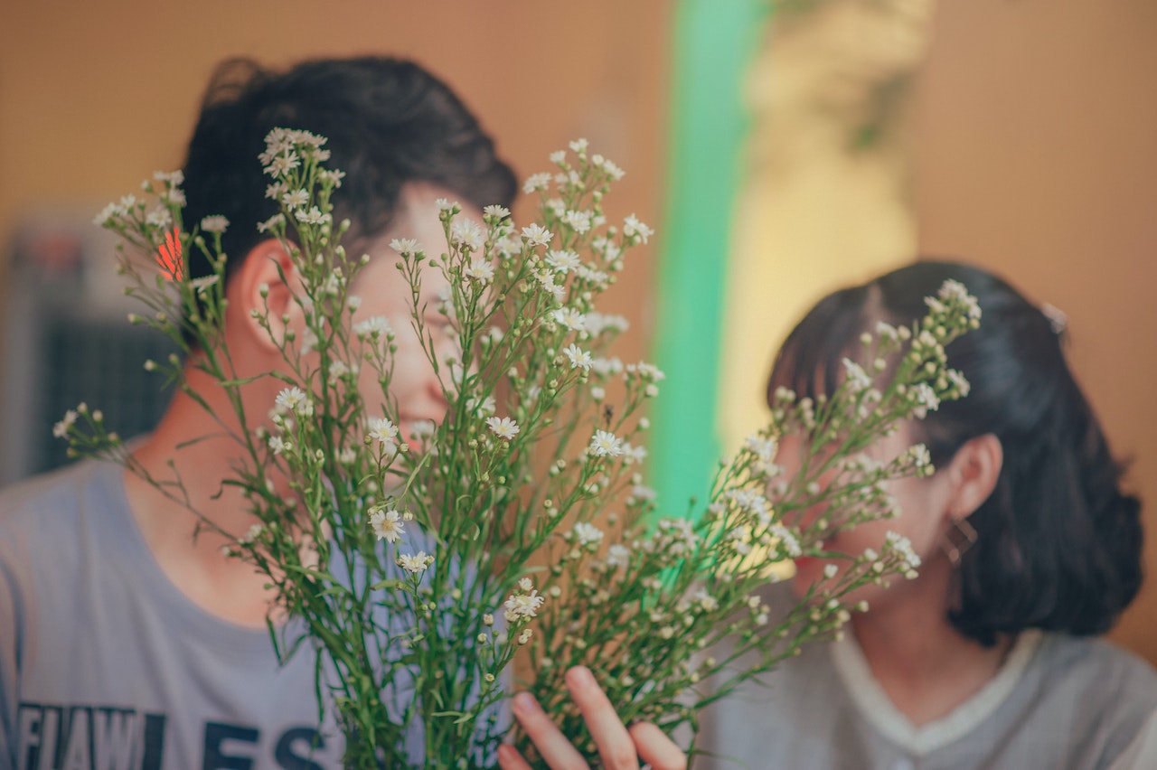 Man and Woman Behind the Flowers