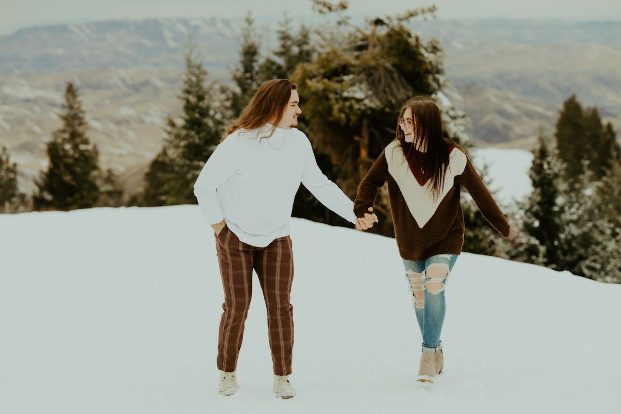 A Couple Walking while Holding Hands during Winter