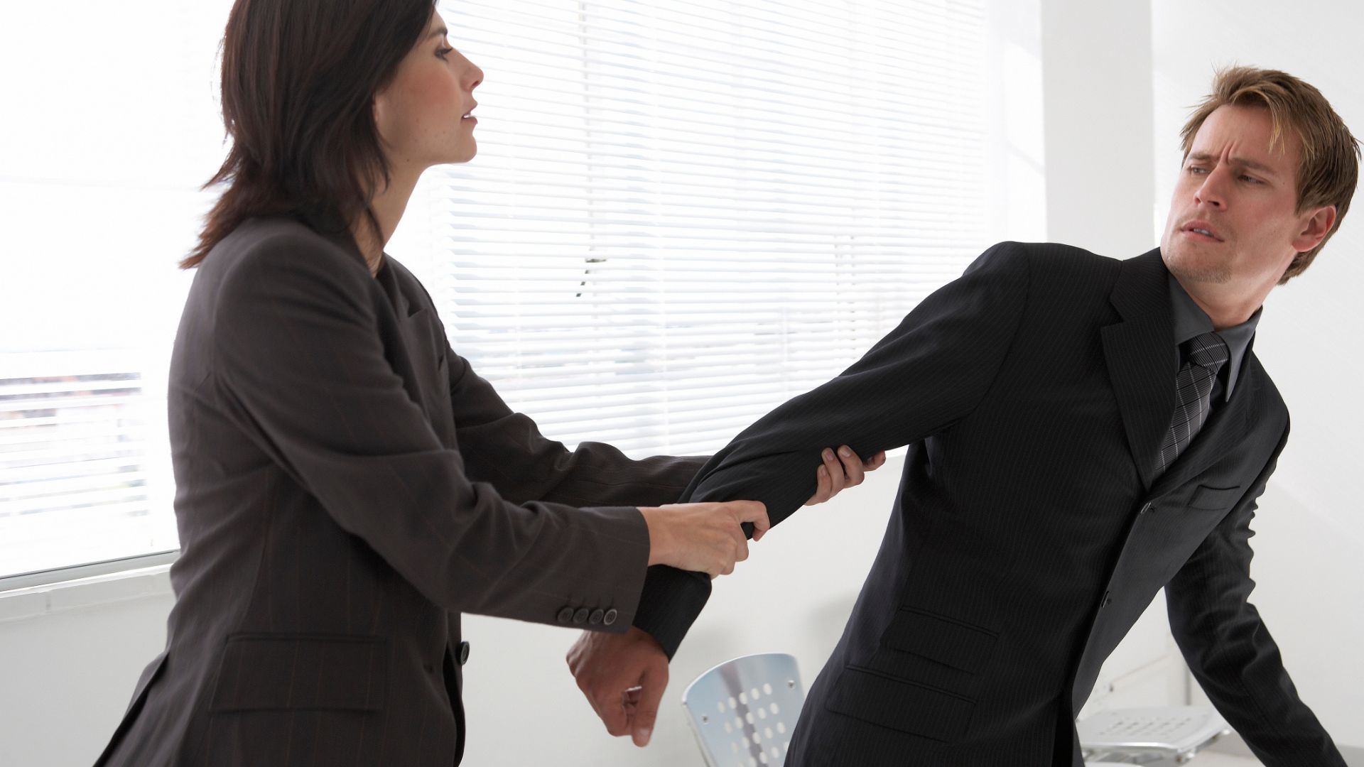 A Woman Holding A Man's Arm Trying to Get Awya from Her