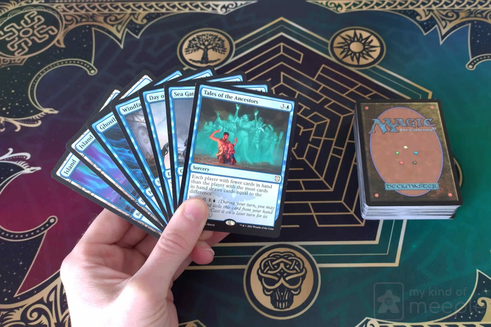 Hand holding a fan of magic cards.