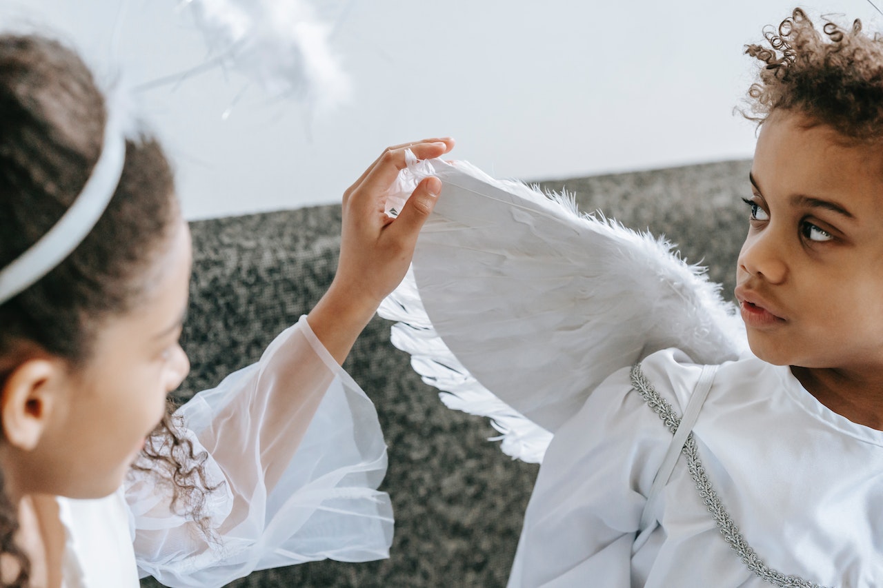 Girl Touching the Wing of Brother's Angel Costume