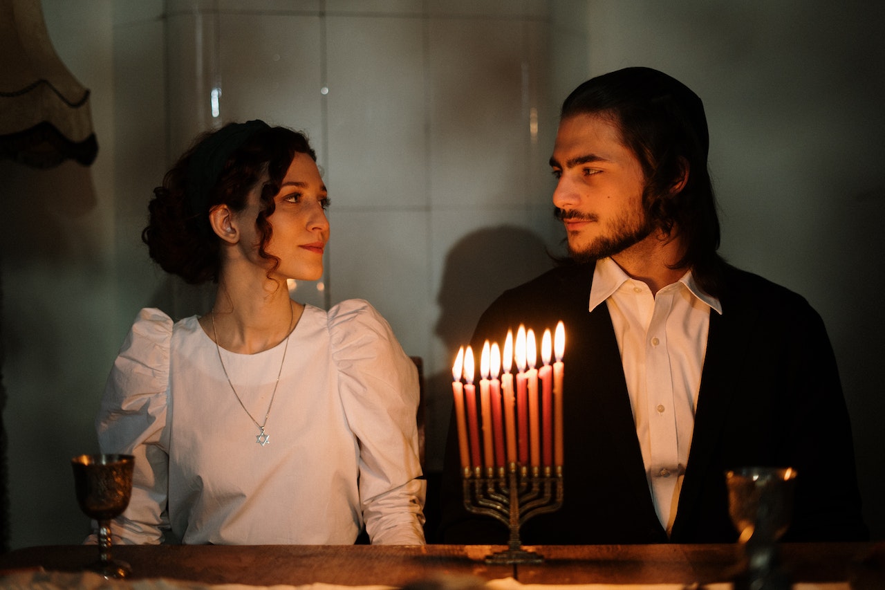 Couple Looking at Each Other with Lit Candles on the Table