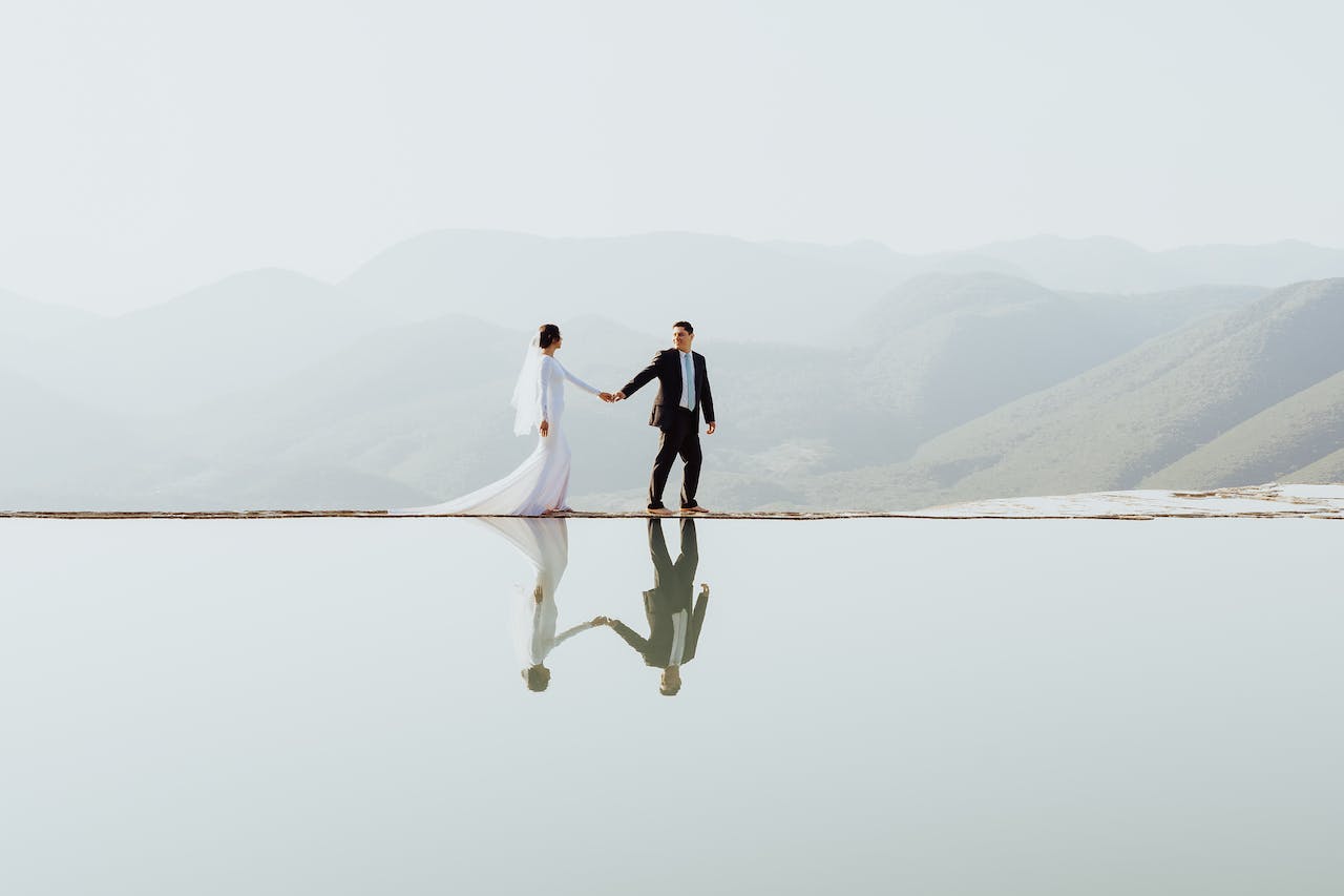 Just Married Couple Walking Beside a Lake