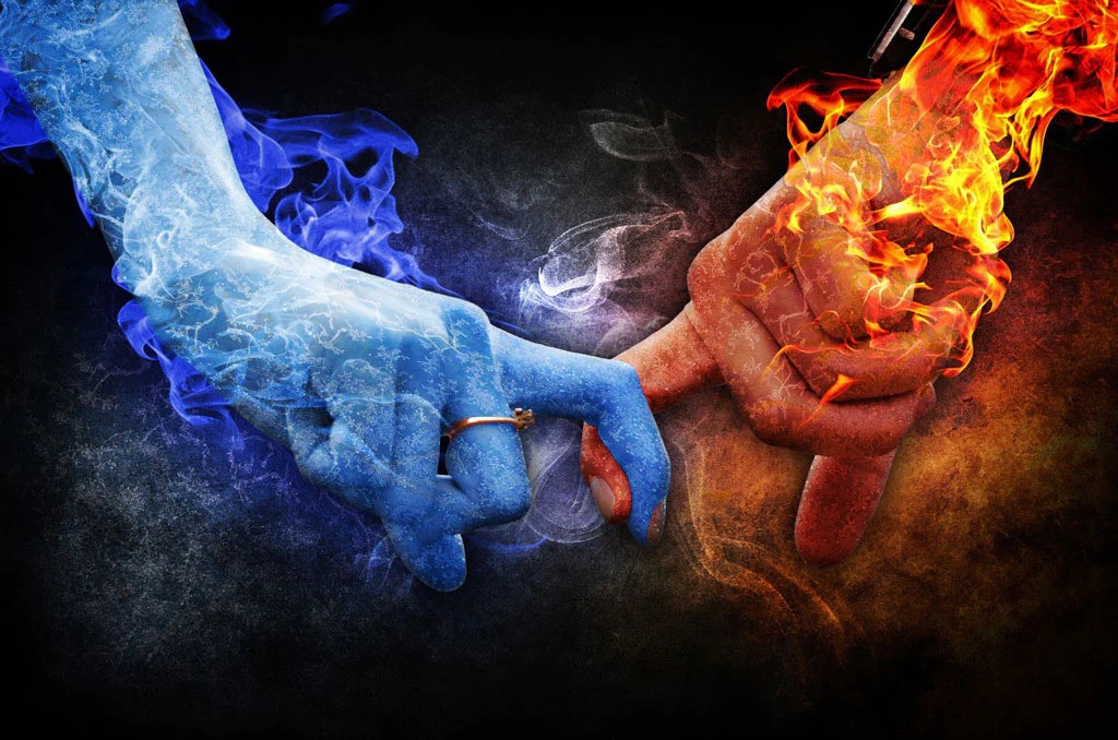 A man's hand in yellow flames holding a woman's hand in blue flames.